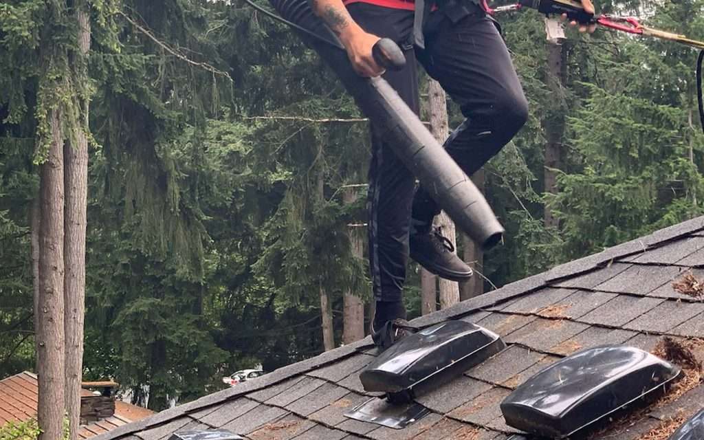beginning to clean roof by blowing leaves off