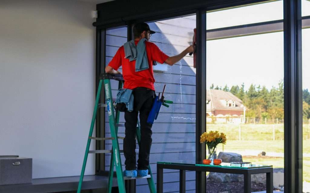 washing inside window on a ladder