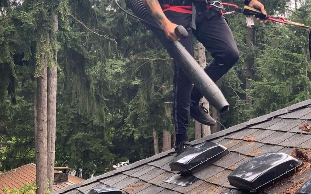 leaf blowing a Tacoma roof to remove debris